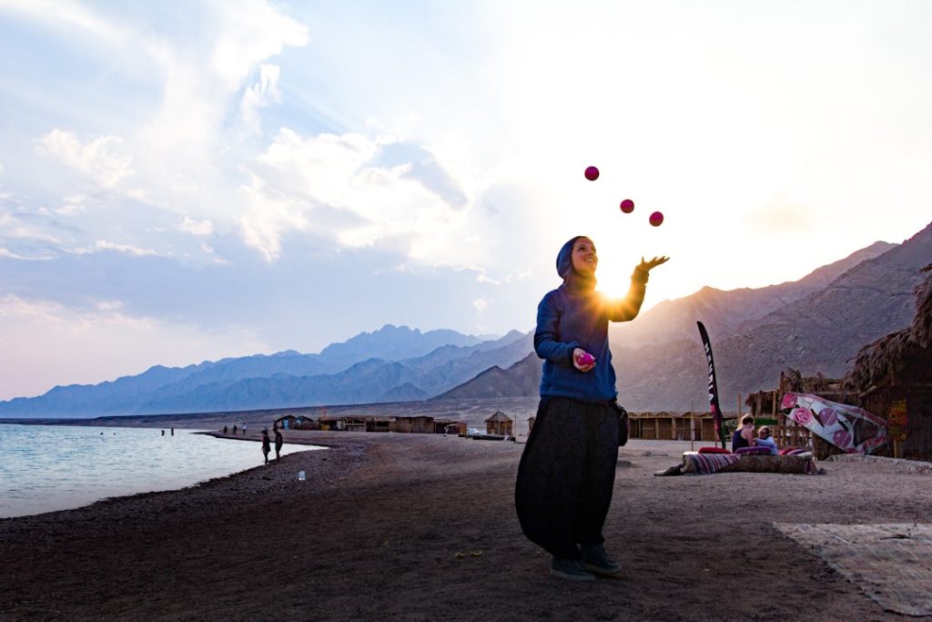 a woman juggling on the beach representing the need to improve delegation skills